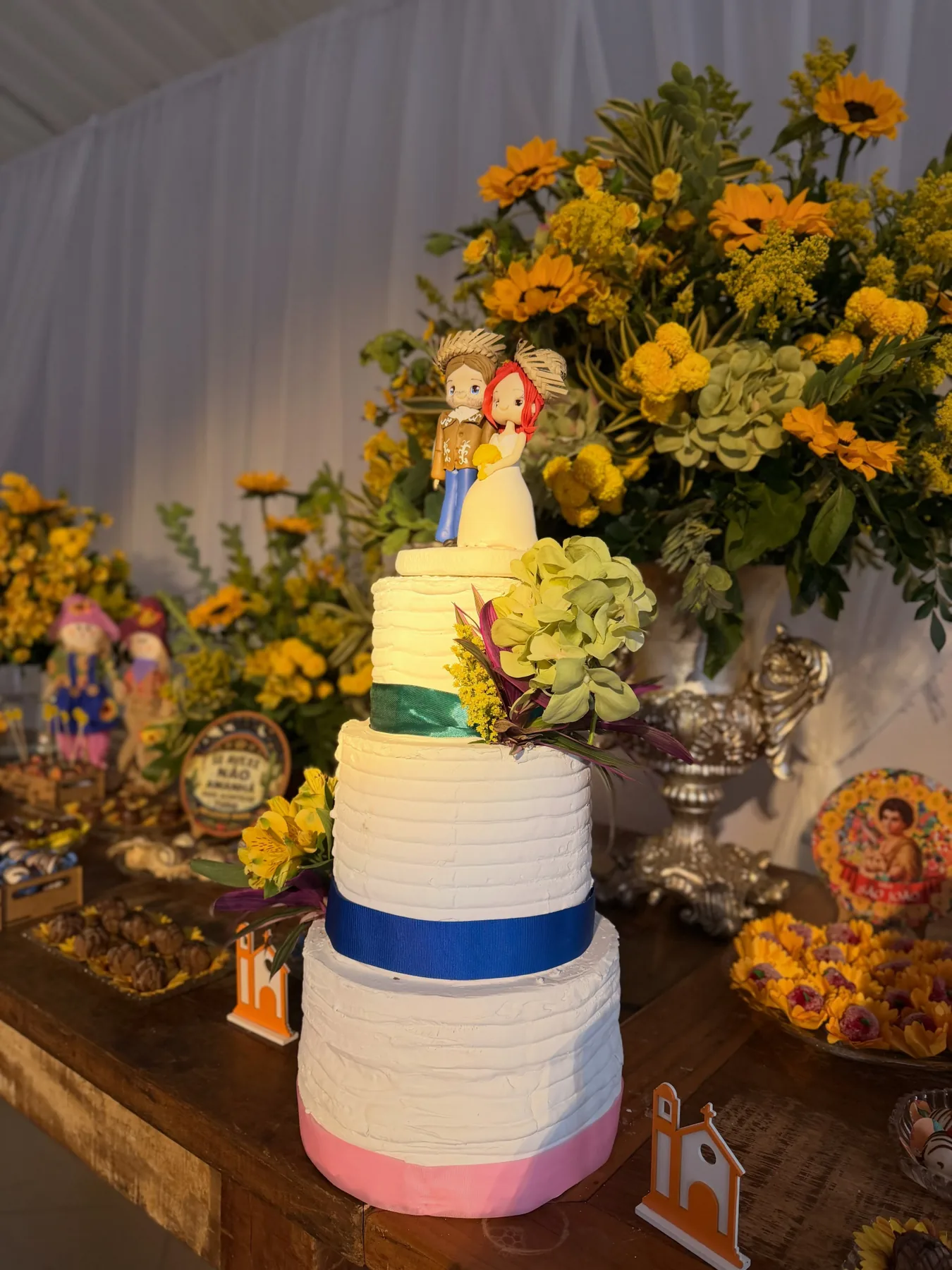 Bolo festivo com flores amarelas e detalhes azuis