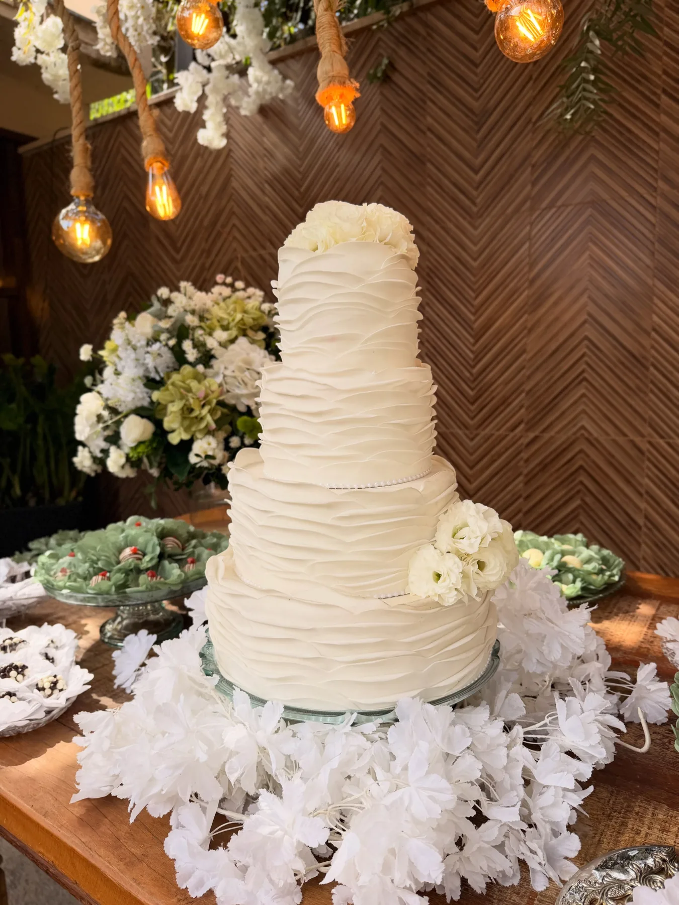 Bolo branco de vários andares decorado com flores